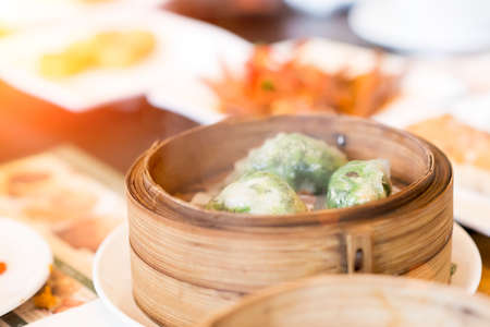 Chinese dim sum in bamboo steamer box on tableの写真素材