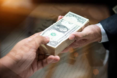 Handcuffs is on the laptop keyboard and Money for corruption,double exposure,Business concept