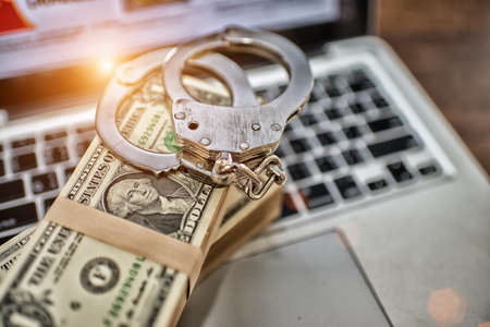 Money for business and Handcuffs is on the laptop keyboard, corruption concept,High Dynamic Range toneの写真素材