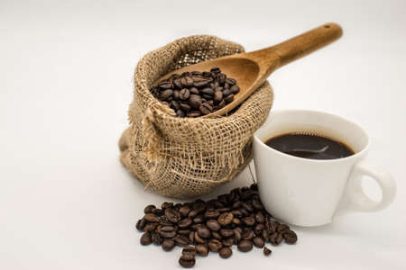 Coffee beans in Cloth bag and wooden and coffee cup spoon isolated on white backgroundの写真素材