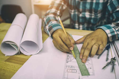 Close up man working of Architect sketching a construction project,film tone