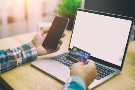 Man hands holding Credit card and phone,laptop with shoping online concept,film toneのeditorial素材
