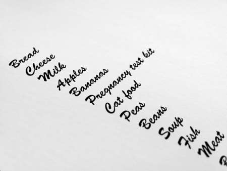 Grocery shopping list with pregnancy testing kit with shallow depth of field