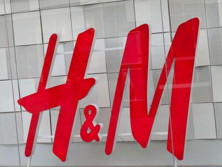 H and M ladies and mens clothing retailer sign in shopfront window, company founded by Erling Persson in 1947のeditorial素材