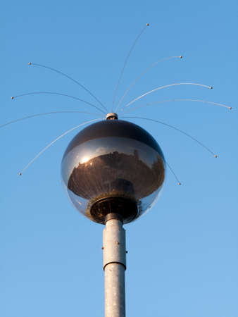 Streetlamp with bird anti perching wires isolated against a clear blue sky