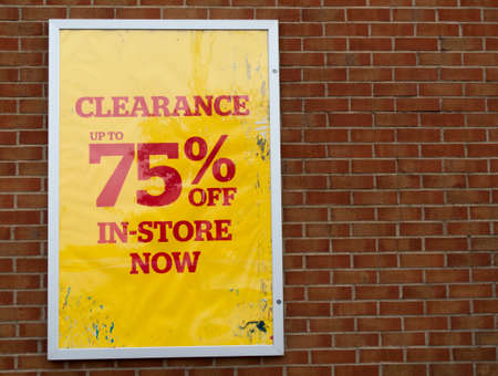 75 percent off in store now retail store clearance sale sign mounted on brick wallのeditorial素材