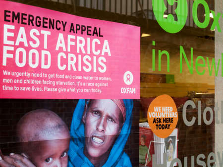 Oxfam emergency appeal poster in charity shop window, East Africa food crisis