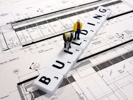 representation of the building industry on technical drawing background with construction workersのeditorial素材
