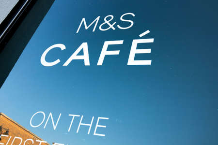 Marks and Spenser sign on shopfront window advertising in store cafe, company founded in 1884 by...