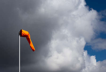 Airfield windsock, used to indicate wind speed and direction, shown deflated due to lack of windの写真素材