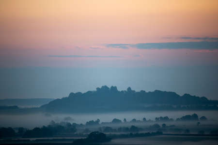 Early morning mist over farmland and woodland in rural Hampshire