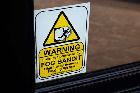 Fog Bandit warning sign displayed on jewellers door, high speed security fogging system to deter...