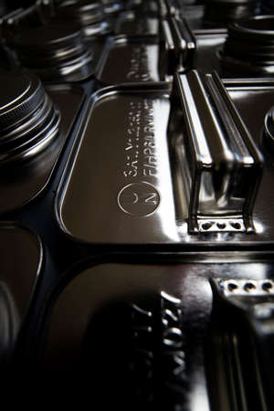 stainless steel jerry cans stacked in warehouse, close up with shallow depth of field