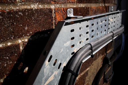 Mild steel heavy duty pre galvanised cable tray mounted on external brick wall to support electrical...