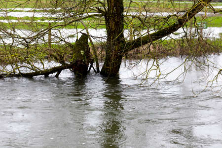 Flooded river after heavy storm rainfall flooding adjacent farmlandの写真素材