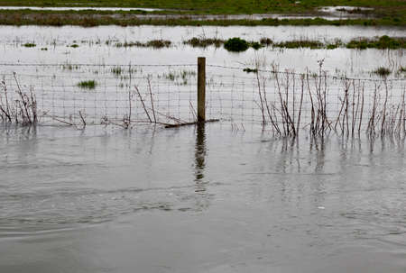 Flooded river after heavy storm rainfall flooding adjacent farmlandの写真素材