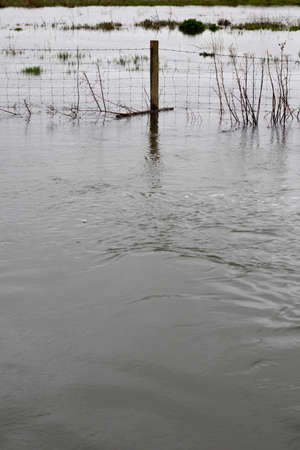 Flooded river after heavy storm rainfall flooding adjacent farmlandの写真素材