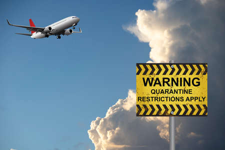 Warning quarantine restrictions apply information sign quarantining incoming international passengers due to the worldwide pandemicの写真素材