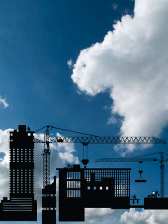 Silhouetted generic urban construction development set against a blue cloudy skyの写真素材