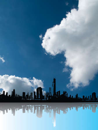 Silhouetted generic city skyline with foreground reflection and blue cloudy sky aboveの写真素材