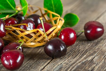 Cherry on a wooden table in a wickerの写真素材