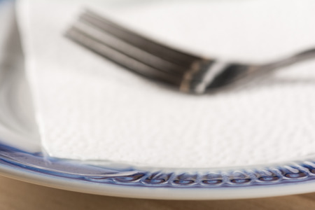 Empty dish and fork on a napkinの写真素材