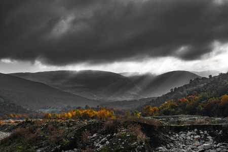 Gray clouds over autumn mountain forestの写真素材