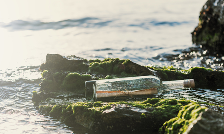 Message in a corked bottle on the shore, hope of salvationの写真素材