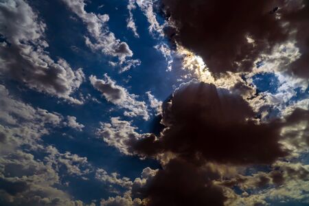 Dark storm clouds on a bright blue sky