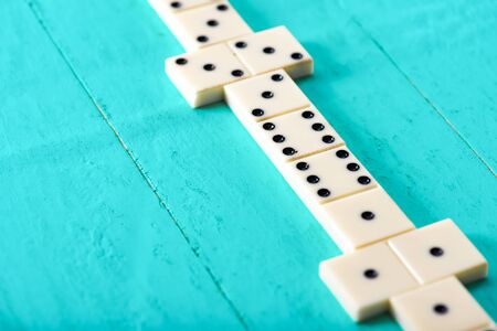 Playing dominoes on a blue wooden tableの写真素材