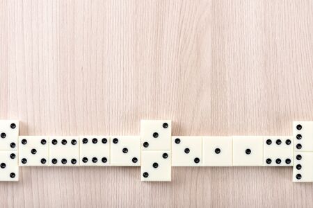 Playing dominoes on a wooden tableの写真素材