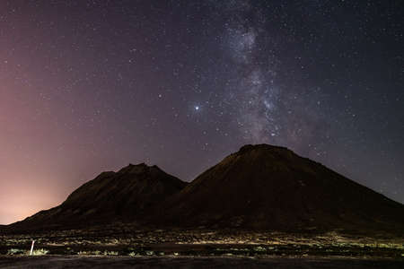 Starry sky with Milky Way galaxy over mountains