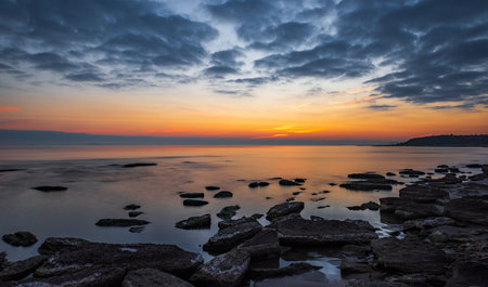 Colorful sunrise on the rocky sea coast, long exposureの写真素材