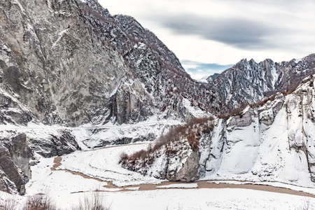 Winter mountain landscape with road and river
