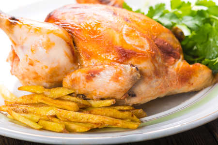 Fried chicken with potatoes on a plateの写真素材