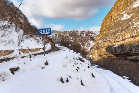 Narrow snowy road in a mountain gorgeの写真素材