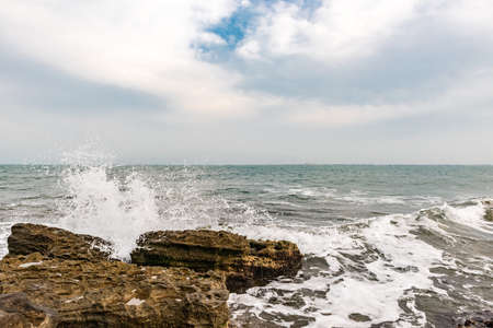 Waves breaking against coastal rocks sceneの写真素材