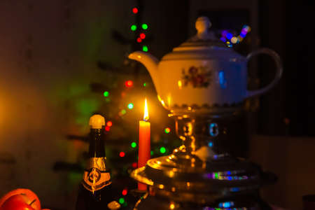 Burning candle by the christmas treeの写真素材