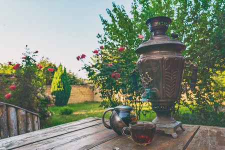 Tea drinking from a vintage samovar in gardenの写真素材