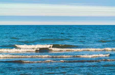 Turquoise sea and horizon with cloudsの写真素材