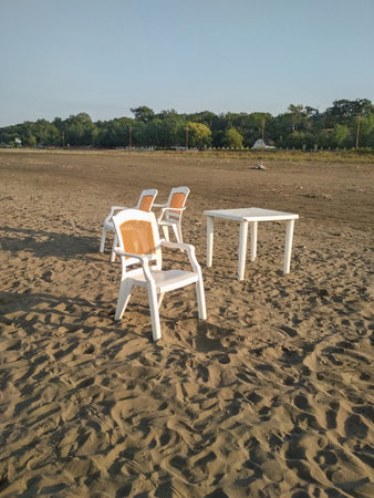 Table with chairs on an empty beachの写真素材