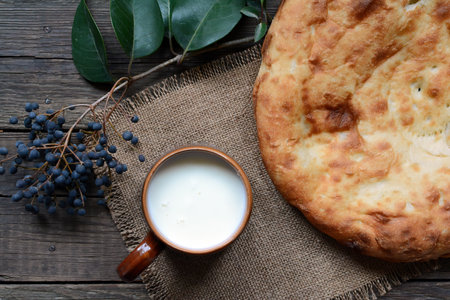 Mug of milk and freshly baked asian bread on wooden table top viewの写真素材