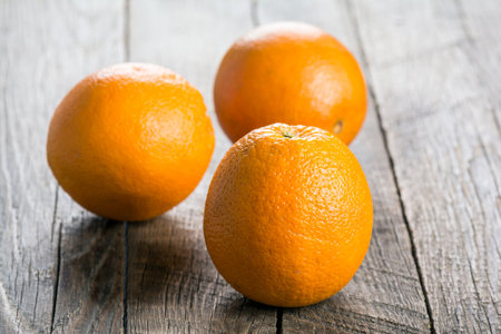 Ripe juicy oranges on a wooden surfaceの写真素材