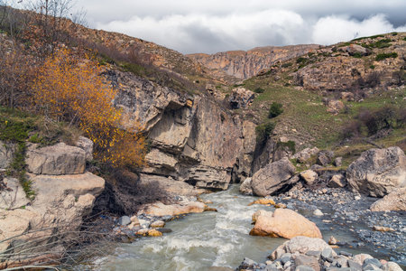 Mountain river flow near big rockの写真素材