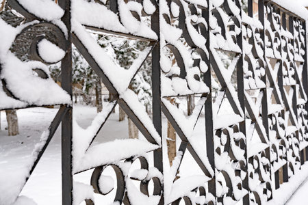 The iron fence of the house is covered with snow in winter.の写真素材