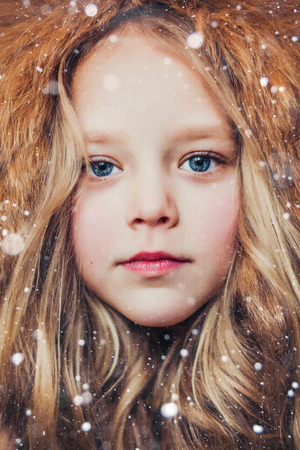 Winter Portrait of a pretty little girl wearing fur hat.の写真素材