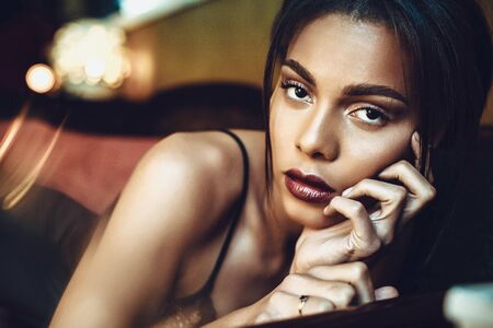 Beautiful dark-skinned young woman sensualy posing in black lingerie. Fashion Photoshoot.の写真素材