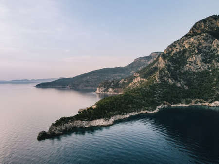 An aerial view of the mountains, sea, green forest and turquoise blue waterの写真素材
