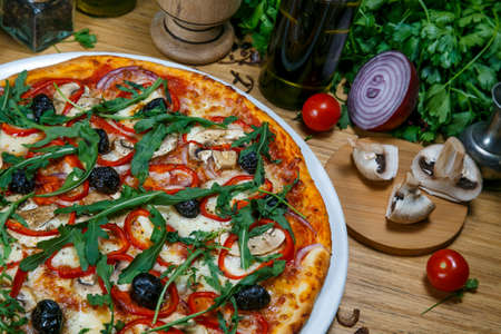 Veggie pizza with mushrooms, cherry tomatoes, black olives and herbs close up. Pizza backgroundの写真素材