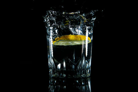 Water and lime splashing in glass, black backround, close upの写真素材